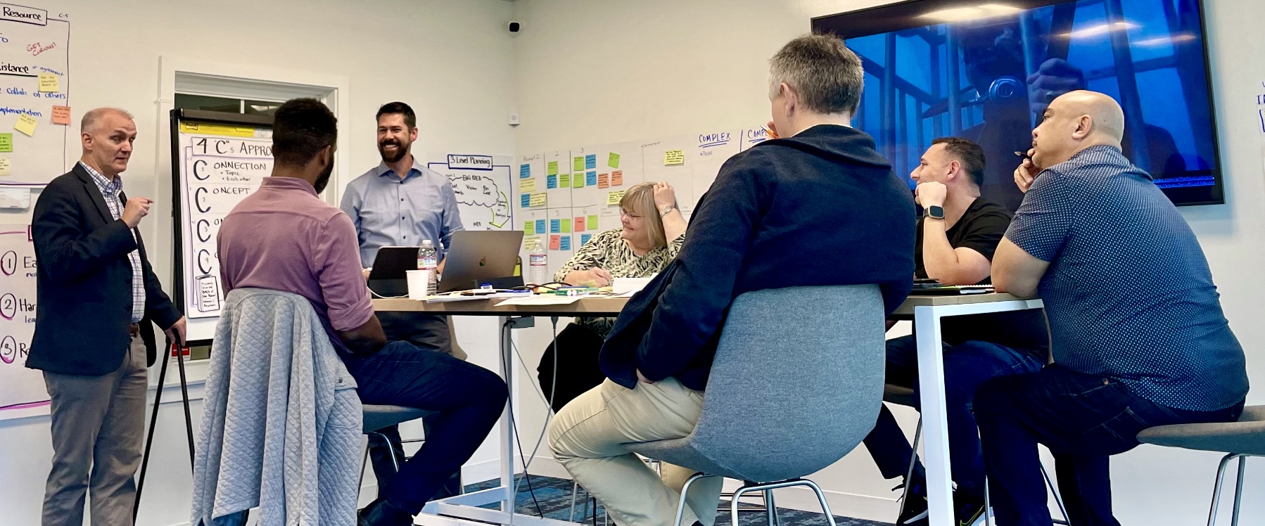 Richard and Peter facilitating a Certified CAPED Consultant workshop, surrounded by planning charts and sticky notes